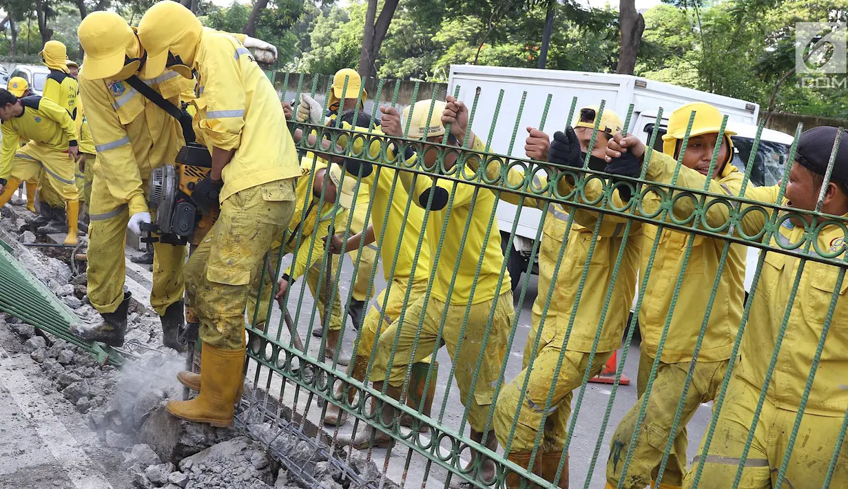 Petugas Dinas Bina Marga membongkar pagar dan sepatator di Jalan Galunggung, Jakarta, Kamis (10/1). Pembongkaran dilakukan guna menghilangkan batas antar jalur sehingga diharapkan dapat mengurai simpul kemacetan. (Liputan6.com/Immanuel Antonius)
