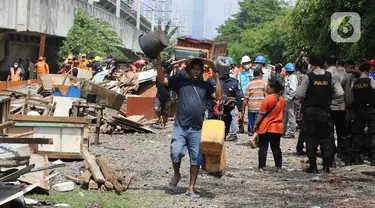 Warga mengangkut barang-barangnya saat penertiban bangunan lokalisasi liar Gunung Antang di Matraman, Jakarta Timur, Selasa (30/8/2022). Sebanyak 120 bangunan liar dibongkar di lahan seluas 2.500 meter persegi milik PT KAI dan selanjutnya akan dijadikan Ruang Terbuka Hijau (RTH). (Liputan6.com/Herman Zakharia)