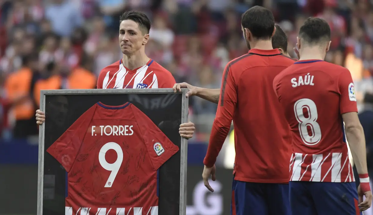 Striker Atletico Madrid, Fernando Torres, menerima jersey usai melawan Eibar pada laga La Liga Spanyol di Stadion Wanda Metropolitano, Madrid, Minggu (20/3/2018). Laga ini merupakan yang terakhir bagi Torres bersama Atletico. (AFP/Gabriel Bouys)