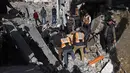 Sejak gencatan senjata mulai diberlakukan di Gaza, kedua pihak bertikai, Israel dan Hamas, saling menuduh telah melanggar kesepakatan. Tampak dalam foto, tim penyelamat dan warga yang menyaksikan kejadian tersebut memeriksa puing-puing kantor polisi Sheikh Radwan di Kota Gaza pada 31 Januari 2026. (Omar AL-QATTAA/AFP)