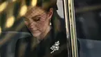 Kate Middleton berada di dalam mobil saat menghadiri prosesi persemayaman Ratu Elizabeth II di Westminster Hall di London (14/9/2022). Kate Middleton yang mendapat gelar baru sebagai Princess of Wales memakai bros berlian dan mutiara berbentuk daun. (AFP/Marco Bertorello)