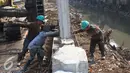 Sejumlah pekerja memasang tiang pancang untuk turap bantaran Kali Ciliwung, Kampung Pulo, Jakarta (26/8/2015). Pemprov DKI Jakarta menargetkan pemasangan turap selesai dalam waktu tiga bulan. (Liputan6.com/Gempur M Surya)