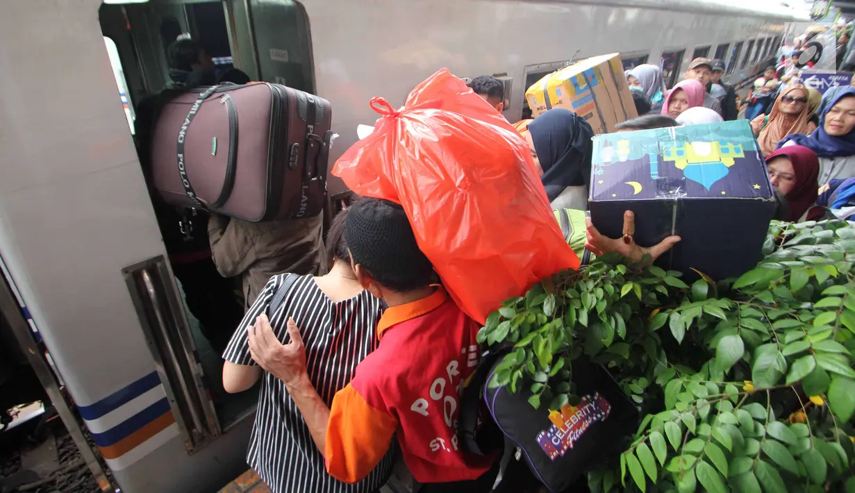 Peserta mudik gratis bareng PDIP menaiki kereta api di Stasiun Pasar Senen, Jakarta, Selasa (12/6). PDIP memberangkatkan 725 pemudik dengan kereta api pada hari ini. (Liputan6.com/Angga Yuniar)