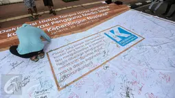 Peserta menandatangani spanduk “Deklarasi Hidup Tanpa Hoax dan Fitnah di kawasan Bundaran HI, Jakarta, Minggu (29/1). Aksi itu untuk meningkatkan kewaspadaan terhadap berita hoax dan fitnah terutama menjelang Pilkada Serentak. (Liputan6.com/Faizal Fanani)