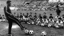 Pemain sepak bola Brasil Edson Arantes do Nascimento atau Pele melatih anak-anak saat perjalanannya ke Bangkok, Thailand, 6 Desember 1974. Kendati sudah memutuskan untuk pensiun, Pele tatap terlibat dalam olahraga dengan bekerja sebagai pandit di televisi dan menjabat sebagai Menteri Olahraga di Brasil antara tahun 1995 dan 1998. (AFP)