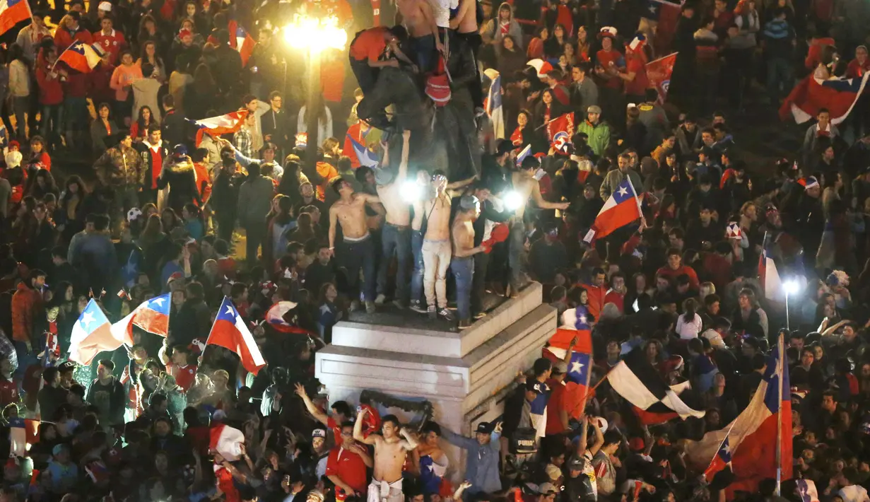 Warga Cile merayakan gelar juara Copa America 2015 di pusat kota Santiago, Cile. (REUTERS/Carlos Garcia Rawlins)