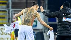 Striker AC Milan, Zlatan Ibrahimovic, menukar jersey saat melawan Cagliari pada laga Liga Italia di Sardegna Arena, Senin (19/1/2021). AC Milan menang dengan skor 2-0. (AFP/Alberto Pizzoli)