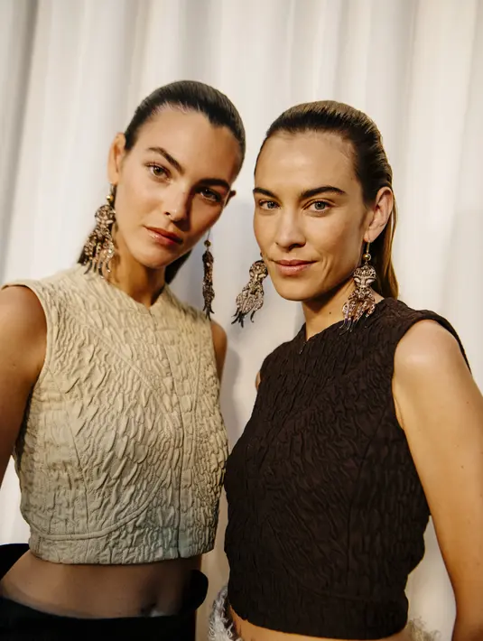 Koleksinya menafsirkan ulang elemen sporty dengan fokus pada kebebasan dan pelarian. Koleksi utamanya mencakup pakaian renang berpayet, ikat pinggang yang terinspirasi dari seni bela diri, dan sweater dengan warna blok. Penggunaan jahitan dan quilting mempertegas garis alami tubuh, sementara rok menampilkan detail kawat untuk menonjolkan lekuk tubuh. Rok sifon bertingkat yang dipadukan dengan leher V berbahan katun mengeksplorasi sensualitas dan draping. [Dok/Tory Burch].