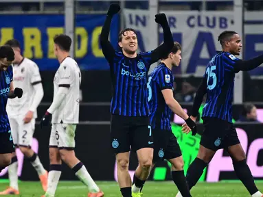 Gelandang Inter Milan asal Polandia, Piotr Zielinski (tengah) merayakan golnya dalam pertandingan pekan ke-17 Serie A Italia melawan Bologna di Stadion San Siro, Milan, Minggu (4/1/2026) waktu setempat atau Senin (5/1/2026) dini hari WIB. Inter Milan memastikan kembali ke puncak klasemen usai meraup poin penuh pada pertandingan pekan ke-18 Serie A Italia 2025/2026. (Piero CRUCIATTI/AFP)