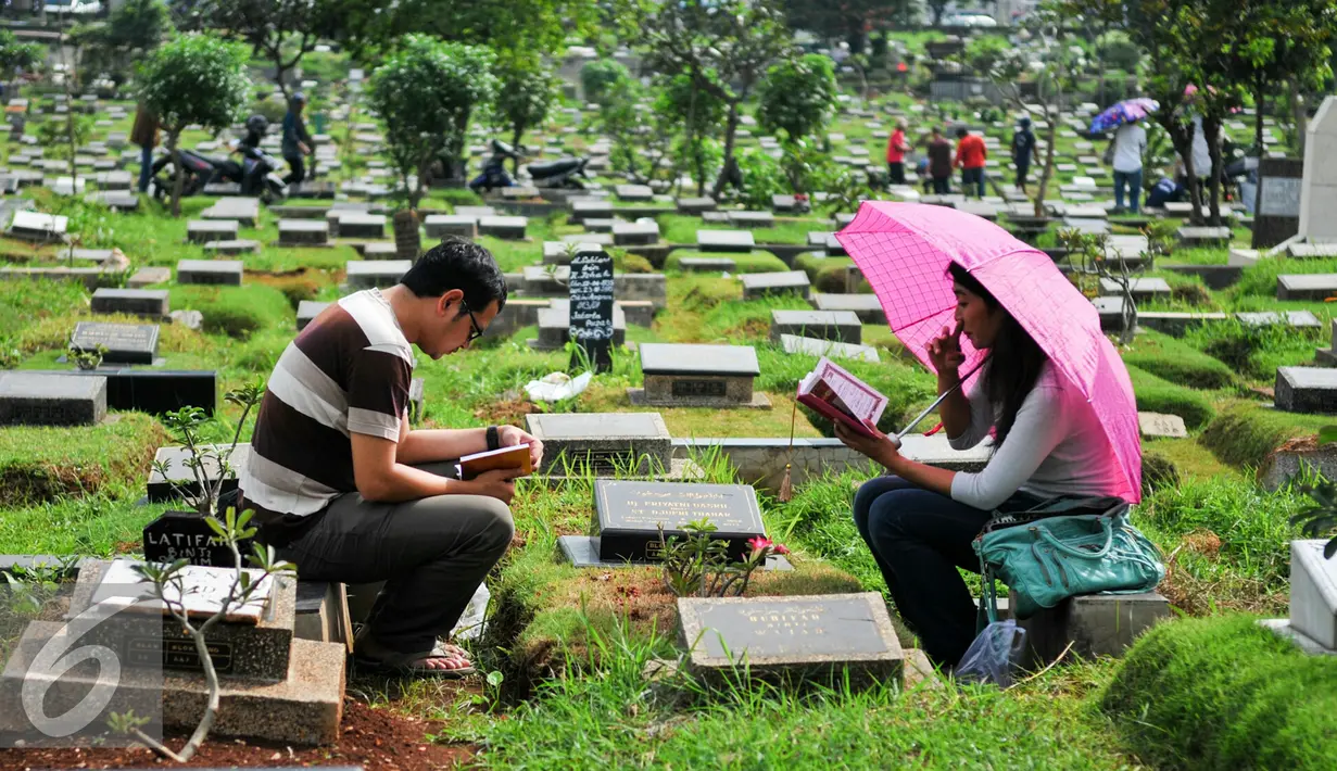 Warga membacakan doa di makam keluarganya menjelang bulan puasa di TPU Karet Bivak, Jakarta, Minggu (29/5/2016). Jelang bulan Ramadan, umat Muslim mulai ramai berziarah ke makam keluarganya. (Liputan6.com/Yoppy Renato)