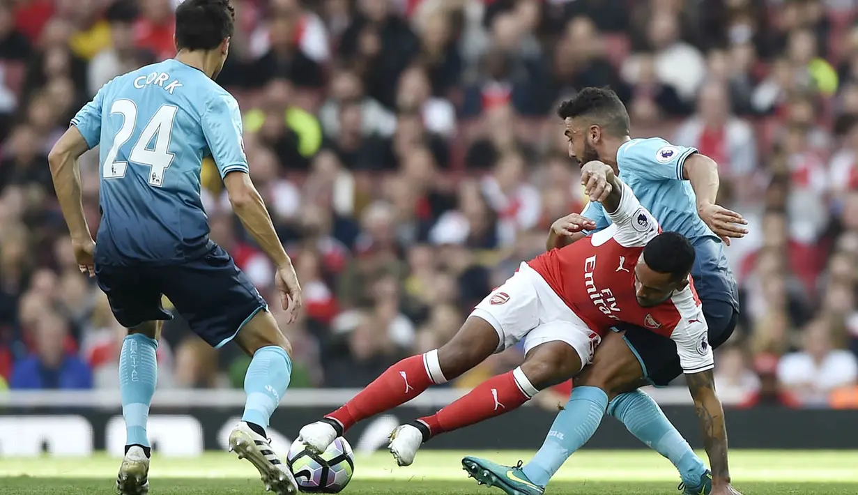 Penyerang Arsenal, Theo Walcott, terjatuh saat berebut bola dengan pemain Everton pada laga Premier League di Stadion Emirates, London, Sabtu (15/10/2016). Arsenal menang 3-2 atas Swansea. (Reuters/Hannah McKay)