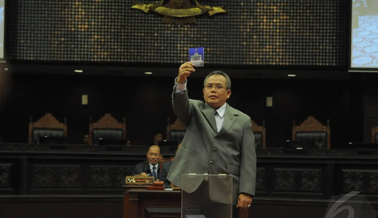 Hakim Konstitusi, Aswanto saat saat menunjukkan kertas suara dalam pemilihan Ketua dan Wakil Ketua MK di Gedung MK, Jakarta, Senin (12/1/2015). (Liputan6.com/Herman zakharia)