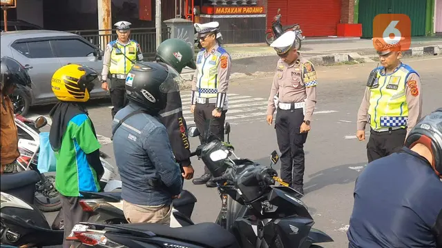 Para pengendara di Jalan Bundaran Tugu Adipura Kota Sukabumi, berhenti serentak menundukan kepala untuk mengheningkan cipta dalam peringati Hari Pahlawan Nasional (Liputan6.com/Fira Syahrin)