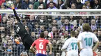 Kiper Atletico Madrid, Jan Oblak, mengamankan gawangnya dari tendangan pemain Real Madrid pada laga La Liga Spanyol di Stadion Santiago Bernabeu, Madrid, Minggu (8/4/2018). Kedua klub bermain imbang 1-1. (AFP/Javier Soriano)