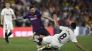 Gelandang Barcelona, Lionel Messi, berusaha melewati gelandang Valencia, Carlos Soler, pada laga Copa del Rey di Stadion Benito Villamarin, Sevilla, Sabtu (25/5). Barcelona kalah 1-2 dari Valencia. (AFP/Pau Barrena)