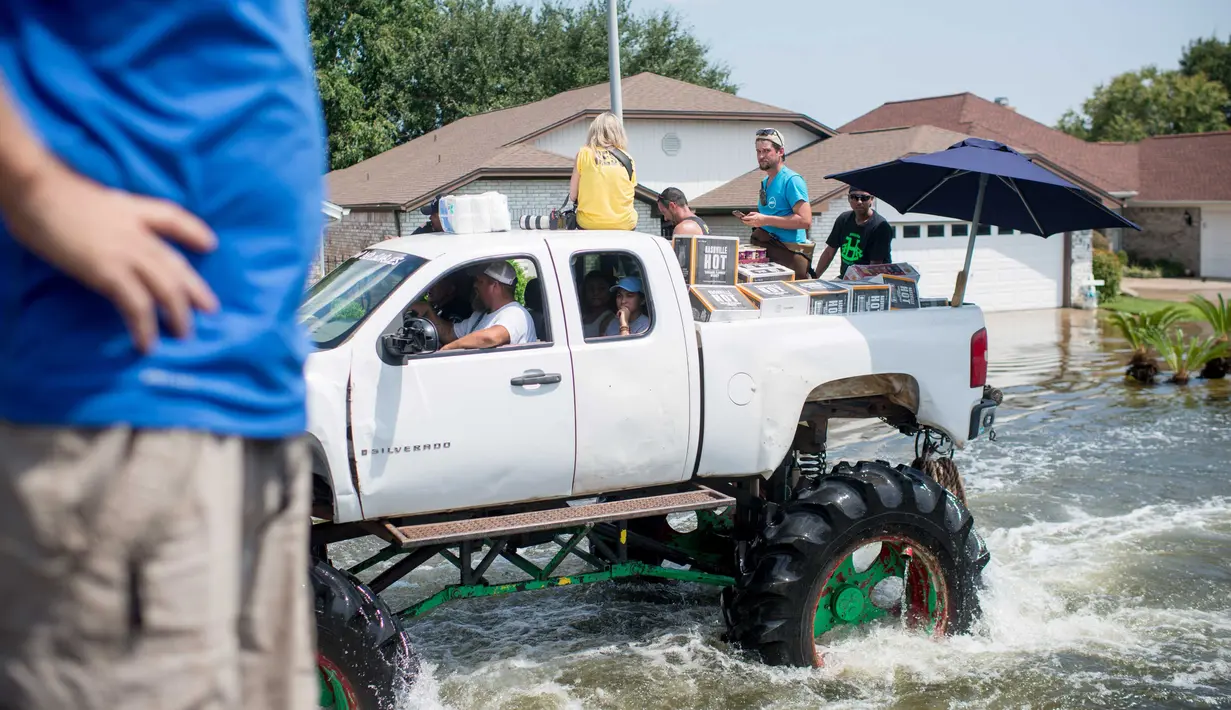 Truk monster menerobos genangan air saat membantu warga yang menjadi korban Badai Harley di Port Arthur, Texas, AS (1/9). Truk raksasa ini menjadi salah satu kendaraan yang diandalkan usai Badai Harley menghantam Texas. (AFP Photo/Emily Kask)
