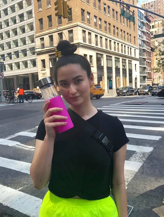 Berpose di sebuah jalan, gadis kelahiran tahun 2000 ini tampak cantik dengan rambut yang diikat ke atas. Menggunakan baju hitam dan celana berwarna hijau cerah, ia tampak memamerkan botol minumannya. (Liputan6.com/IG/@stephaniepoetri)