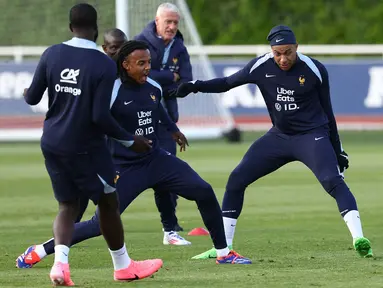 Penyerang Prancis Kylian Mbappe (kanan) berebut bola dengan bek Prancis Jules Kounde (tengah) saat mereka mengambil bagian dalam sesi Latihan sebagai bagian dari persiapan timnas untuk pergelaran Euro 2024 mendatang, di Clairefontaine-en-Yvelines, Kamis (30/5/2024). (FRANCK FIFE / AFP)