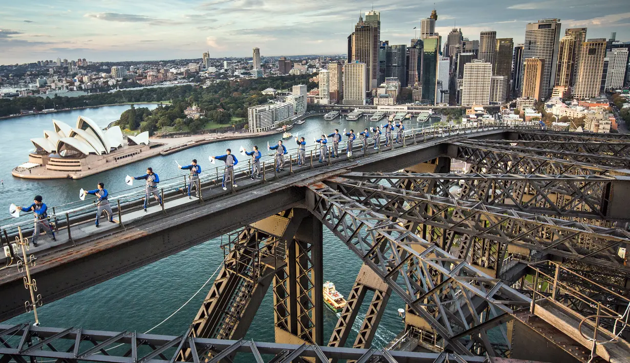 Sejumlah praktisi Tai Chi melakukan latihan di atas Jembatan Sydney Harbour, Australia, Selasa (2/5). Ini merupakan pertama kalinya para prakstisi Tai Chi berlatih di atas puncak jembatan setinggi 134 meter. (Handout / BRIDGECLIMB SYDNEY / AFP)