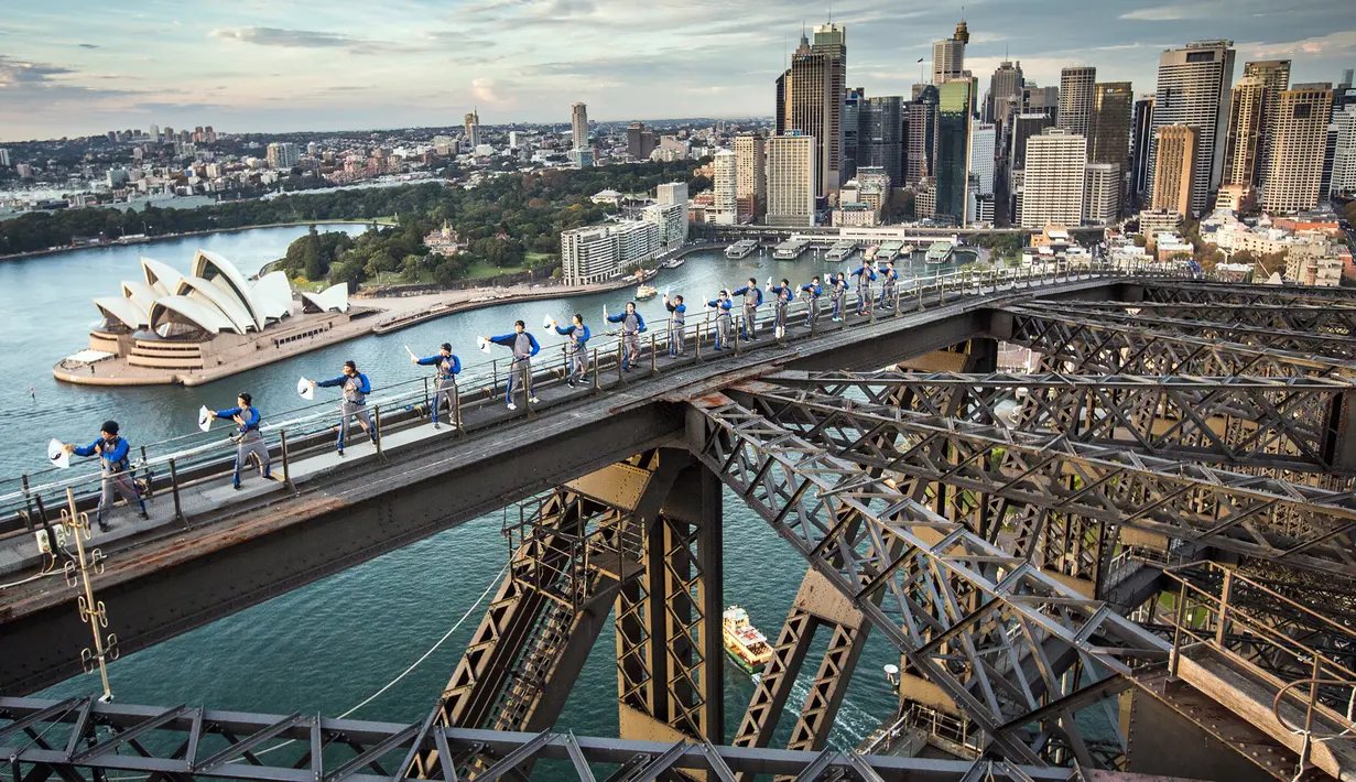 Sejumlah praktisi Tai Chi melakukan latihan di atas Jembatan Sydney Harbour, Australia, Selasa (2/5). Ini merupakan pertama kalinya para prakstisi Tai Chi berlatih di atas puncak jembatan setinggi 134 meter. (Handout / BRIDGECLIMB SYDNEY / AFP)