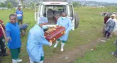 Petugas yang mengenakan pakaian pelindung menurunkan peti mati berisi jenazah balita berusia 3 tahun yang meninggal akibat Ebola saat pemakaman di Bunia, Provinsi Ituri, Kongo timur, Selasa, 18 Agustus 2026. (Foto AP/Dieudonne Dirole)