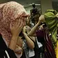 Para wanita asal Maroko menutupi wajahnya saat berada di kantor Imigrasi, Jakarta, Kamis (11/6/2015). Dalam keterangannya, pihak Imigrasi mengamankan sejumlah wanita yang diduga PSK asal Maroko di Bogor, beberapa waktu lalu. (Liputan6.com/Johan Tallo)