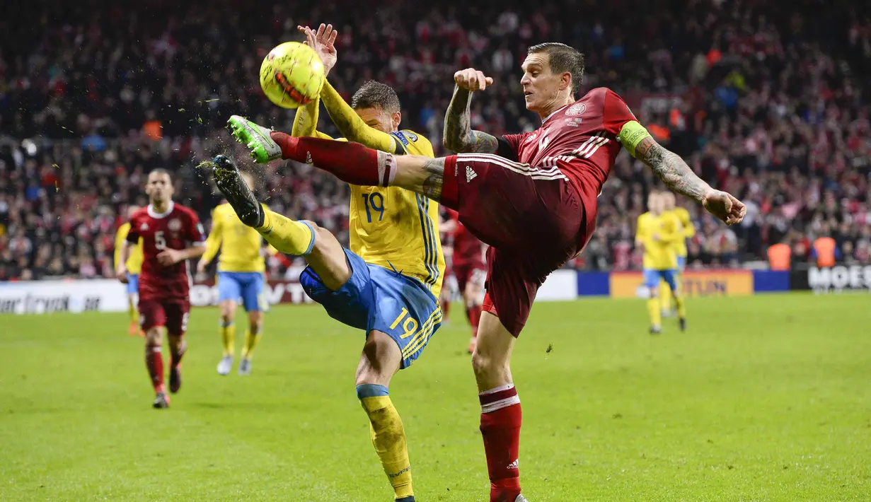 Pemain Swedia Marcus Berg (kiri) berebut bola dengan pemain Denmark Daniel Agger Kapten pada laga kualifikasi piala Eropa Prancis 2016 di Stadion Parken, Kopenhagen,Rabu (18/11/2015) dini hari WIB.  (AFP Photo/Jonathan Nackstrand) 