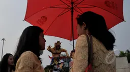 Sejumlah warga meramaikan acara pawai ogoh-ogoh di kawasan Monumen Nasional (Monas), Jakarta, Jumat (20/3/2015). Pawai tersebut merupakan rangkaian dari prosesi menjelang Hari raya Nyepi Tahun Saka 1937. (Liputan6.com/Johan Tallo) 
