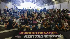 Keluarga dan pendukung warga Israel yang disandera oleh militan Hamas di Gaza sejak serangan pada 7 Oktober 2023, meneriakkan slogan-slogan saat mereka memblokir arus lalu lintas di sebuah terowongan di Yerusalem pada 17 Agustus 2025. (Menahem Kahana/AFP)