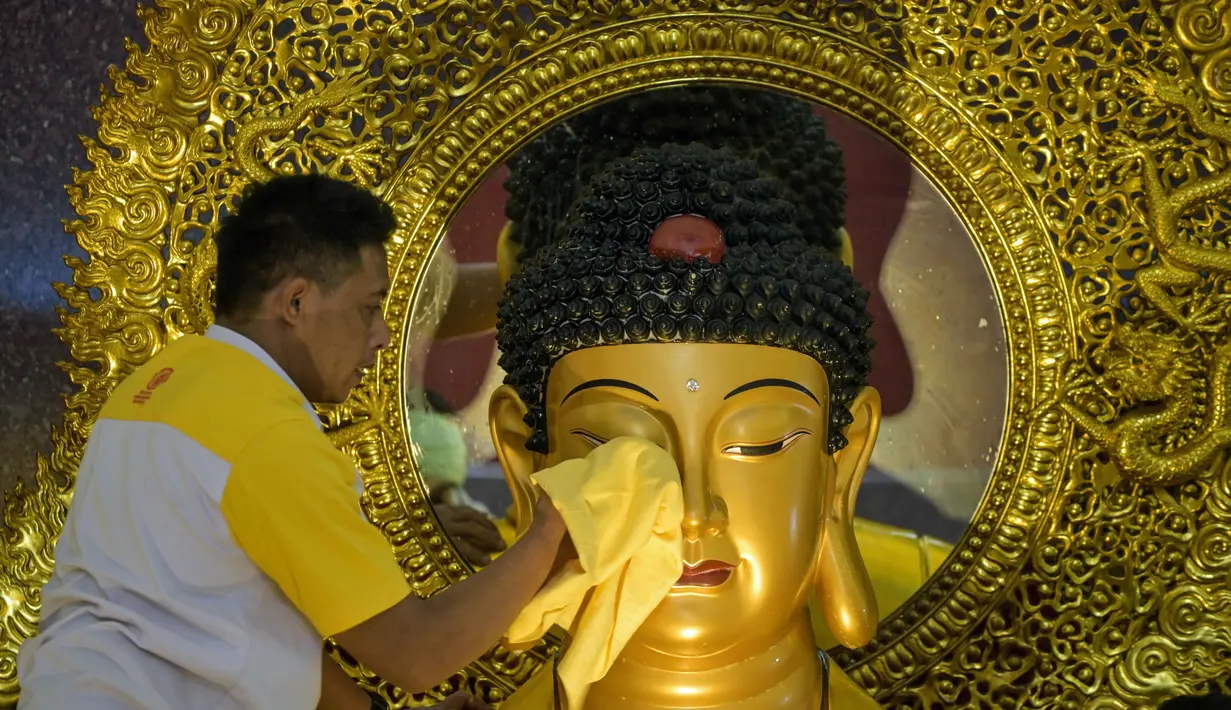 Sebagai informasi, Tahun Baru Imlek 2026 atau Tahun Baru Imlek 2577 Kongzili akan jatuh pada Selasa 17 Februari 2026. Tampak dalam foto, seorang pria membersihkan patung Buddha sebagai persiapan perayaan Tahun Baru Imlek 2577 Kongzili di Vihara Buddhayana, Surabaya, Jawa Timur pada Senin 9 Februari 2026. (JUNI KRISWANTO/AFP)