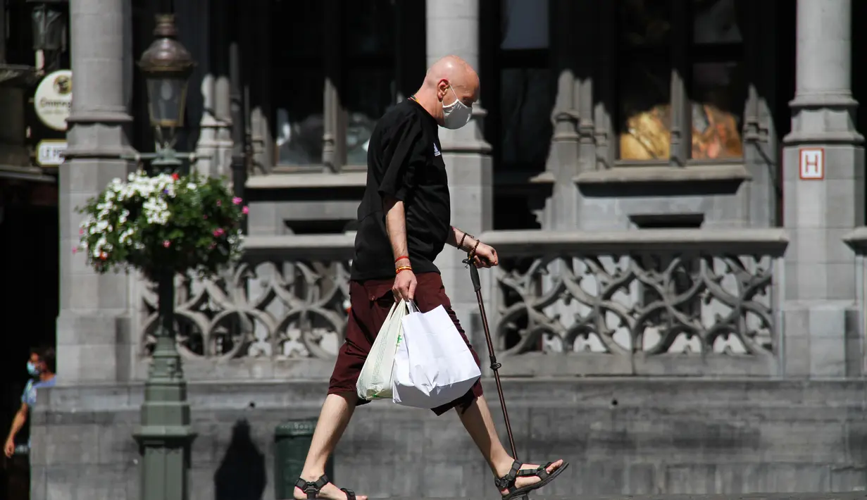 Seorang pria yang mengenakan masker melewati sebuah jalan di Brussel, Belgia (5/8/2020). Kota Brussel memperluas aturan wajib pakai masker di wilayahnya hingga termasuk di jalan-jalan yang ramai dan zona pejalan kaki. (Xinhua/Zheng Huansong)
