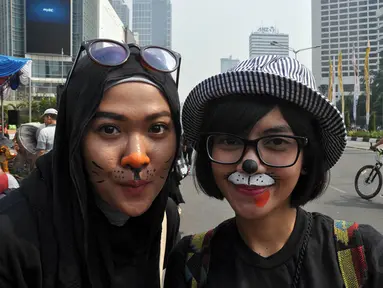 Para peserta tampak melukiskan wajahnya saat mengikuti aksi Karnaval untuk Bumi, Jakarta, (12/10/14). (Liputan6.com/Miftahul Hayat)