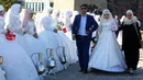 Pasangan yang baru menikah menghadiri perayaan Rusia City Day di Grozny, Rusia, (5/10). Sebanyak 199 pasangan menikah di Taman Bunga Grozny pada perayaan tersebut. (AP Photo / Musa Sadulayev)