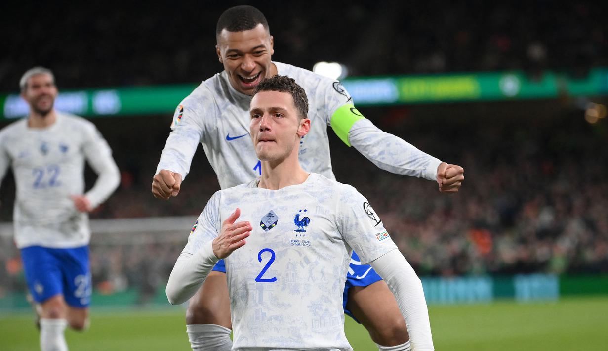 Pemain Timnas Prancis, Benjamin Pavard (depan) melakukan selebrasi setelah mencetak gol ke gawang Timnas Iralandia pada laga laga Grup B Kualifikasi Euro 2024 di Stadion Aviva, Dublin, Irlandia, Selasa (28/03/2023) WIB. Les Bleus berhasil meraih kemenangan tipis 1-0. (AFP/Franck Fife)