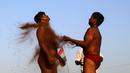 Pegulat melumuri tubuh dengan tanah sebelum berlaga Indian traditional wrestling competition atau Kushti di Arena Akhara, Mumbai, 20 Maret 2016. Olahraga tradisional ini terus dilestarikan sebagai bagian dari budaya. (EPA/Divyakant Solanki)
