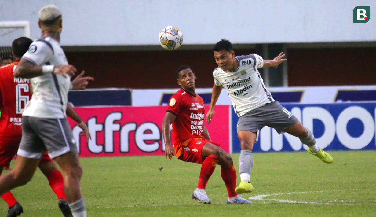 Gelandang Persib Bandung, Dedi Kusnandar (kanan) menyundul bola dalam pertandingan pekan ke-23 BRI Liga 1 2022/2023 melawan Bali United di Stadion Maguwoharjo, Sleman, Jumat (10/02/2023) WIB. (Bola.com/Maheswara Putra)