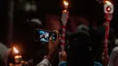 Warga mengambil foto saat mengikuti pawai obor menyambut Ramadan di kawasan Matraman Dalam, Jakarta, Minggu (27/3/2022). Pawai obor tersebut juga digelar untuk meningkatkan silaturahmi dan ukhuwah sesama umat Muslim serta menyemarakkan syiar Islam di Ibu Kota. (Liputan6.com/Faizal Fanani)