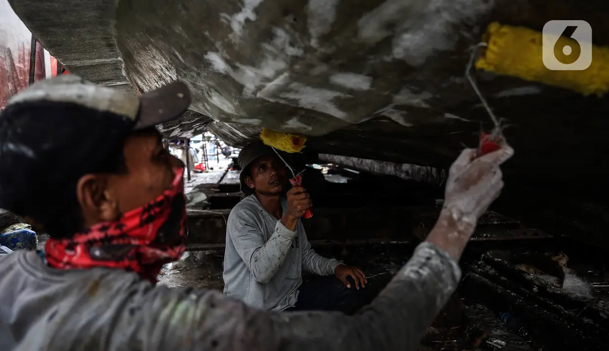 Aktivitas pekerja saat memperbaiki kapal di sebuah galangan kapal kawasan Muara Angke, Jakarta Utara, Kamis (3/6/2021). Butuh 10 hingga 20 pekerja docking kapal untuk memperbaiki satu kapal ikan berjenis 30 GT yang memakan waktu 1 sampai 4 bulan. (Liputan6.com/Johan Tallo)