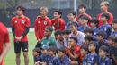 Takumi Minamino dan sejumlah pemain Timnas Jepang mendengarkan pesan dari perwakilan sejumlah anak-anak yang tergabung ke dalam sekolah sepak bola Jakarta Japan Club sebelum sesi latihan yang berlangsung di Lapangan A, Senayan, Jakarta, Selasa (12/11/2024). (Bola.com/Bagaskara Lazuardi)
