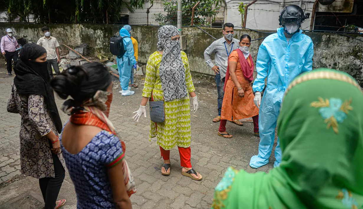 Sukarelawan petugas kesehatan dari LSM India Bharatiya Jain Sanghatana mengenakan helm pintar untuk melakukan screening kasus COVID-19 dari pintu ke pintu di Mumbai, 21 Juli 2020. Helm tersebut menjadi senjata utama bagi Mumbai dalam upaya memberantas Virus Corona. (INDRANIL MUKHERJEE/AFP)