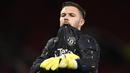 Kiper Manchester United, Jack Butland melakukan pemanasan jelang laga perempatfinal Piala Liga 2022/2023 menghadapi Charlton Athletic di Old Trafford Stadium, Manchester (10/1/2023). Didatangkan dengan status pinjaman selama setengah musim dari Crystal Palace pada Januari 2023 untuk melapis David De Gea, Jack Butland nyatanya hingga kini belum pernah sekalipun dimainkan pelatih Erik ten Hag. Besar kemungkinan ia akan dikembalikan ke Crystal Palace akhir musim ini. (AFP/Oli Scarff)