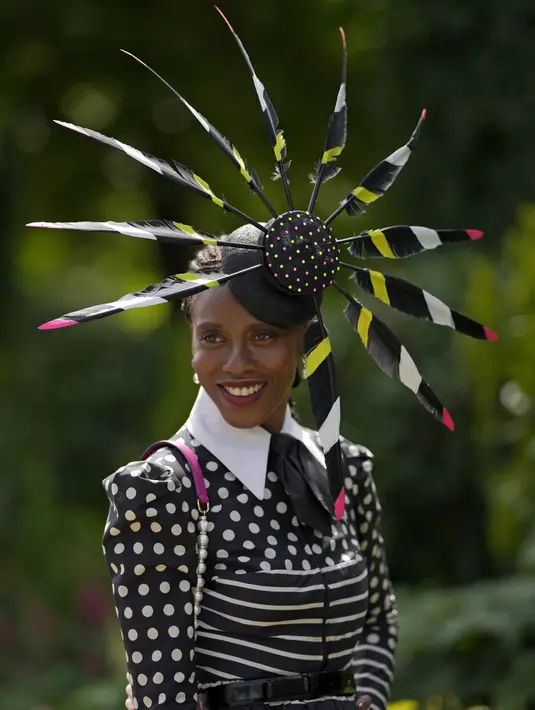 Seorang penonton tersenyum saat berpose untuk foto pada hari ketiga pertemuan pacuan kuda Royal Ascot di Ascot Racecourse, Ascot, Inggris, 16 Juni 2022. Hari ketiga secara tradisional dikenal sebagai Ladies Day. (AP Photo/Alastair Grant)