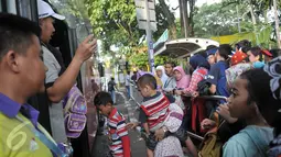 Penumpang antre menaiki bus tingkat wisata di depan halte Masjid Istiqlal, Jakarta, Minggu (30/4). Warga memanfaatkan hari libur panjang mereka dengan berkeliling Jakarta menggunakan bus tingkat ini secara gratis. (Liputan6.com/Yoppy Renato)