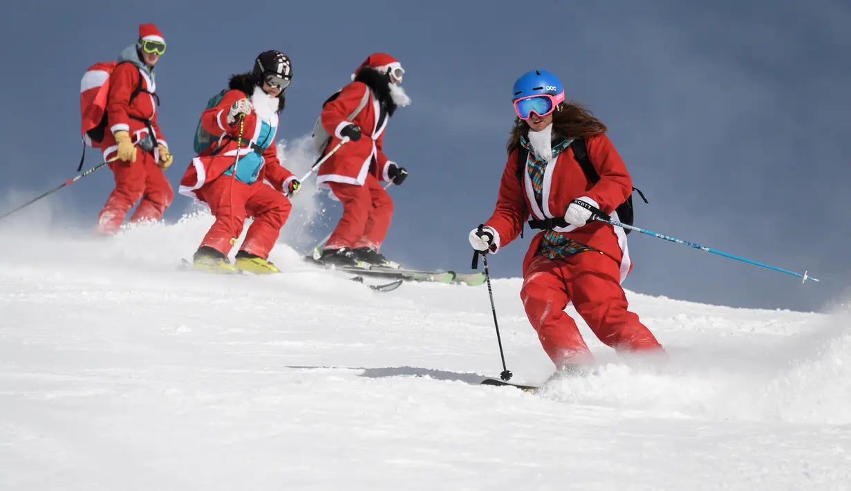 Sejumlah orang mengenakan kostum Santa Claus berselancar diatas salju di resor ski Verbier, Pegunungan Alpen Swiss (2/12). Para pengunjung mengenakan kostum untuk merayakan hari pembukaan musim ski. (AFP Photo/Fabrice Coffrini)