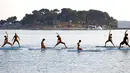 Sejumlah wanita mengenakan bikini saat berlatih yoga Float Metta dengan papan seluncur di Laut Adriatic, Kroasia, Kamis (6/8/2015). (REUTERS/Pawel Kopczynski)
