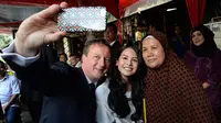 Maudy Ayunda selfie dengan David Cameron dan juga pemilik warung bernama bu Juna (via dailymail.co.uk)