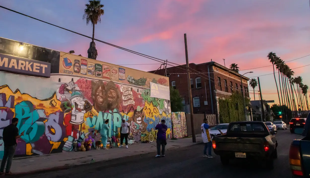 Orang-orang berkumpul di depan mural karya Muck Rock dan Mr79lts yang memperlihatkan Kobe Bryant dan putrinya, Gianna Bryant di Los Angeles, Senin (27/1/2020). Pemain basket legendaris NBA Kobe Bryant bersama putrinya, Gianna tewas dalam kecelakaan helikopter pada Senin (27/1). (Apu GOMES/AFP)