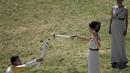 Aktris Yunani, Katerina Lechou, memberikan api olimpiade kepada pembawa obor pertama, Lefteris Peyrounias, dalam suatu upacara di Candi Hera di bekas kota tua Olympia, Yunani, Kamis (21/4/2016). (AFP/Aris Messinis)