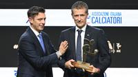 Wasit Italia, Daniele Orsato, berpose di atas panggung setelah menerima penghargaan 'Wasit Terbaik' dari Gianluca Rocchi (kiri) selama acara penghargaan Italian Footballers' Association (AIC) 2023 pada 4 Desember 2023 di Milan. (Marco BERTORELLO/AFP)