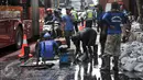 Petugas harian lepas (PHL) dari Sudin Sumber Daya Air dikerahkan untuk membersihkan saluran di Jalan Gatot Subroto, Jakarta, Jumat (10/3). Pembersihan dilakukan karena di kawasan ini banjir selalu datang saat hujan turun. (Liputan6.com/Yoppy Renato)